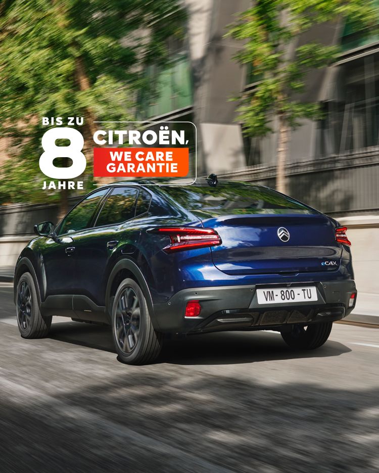 Der neue Citroën ë-C4 X in blau fährt durch eine Stadt. Ansicht von schräg hinten.